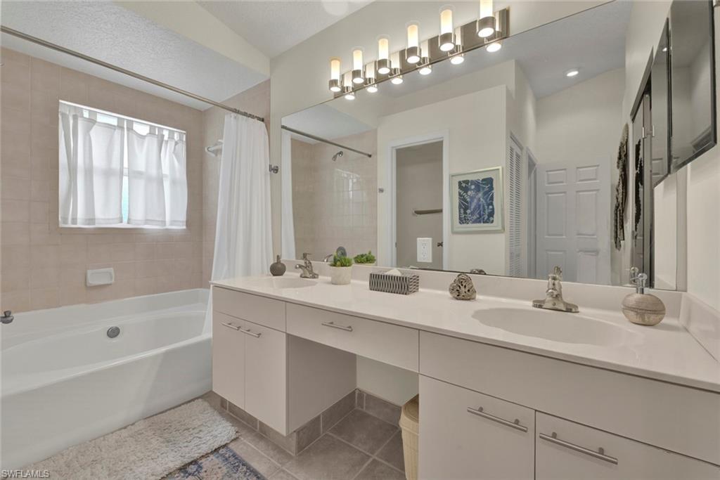 386 Emerald Bay Circle, Unit G4 Naples, FL 34110 - Photo 10 of 20 a bathroom with a sink double vanity granite tub and a mirror