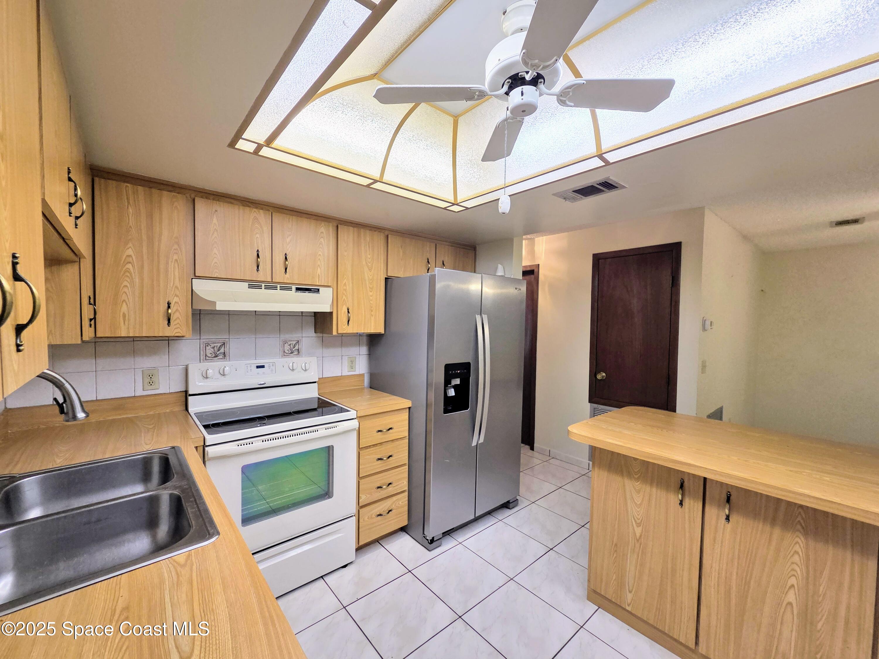 2591 Fulton Court Melbourne, FL 32935 - Photo 12 of 28 a kitchen with stainless steel appliances granite countertop a refrigerator a stove and a sink