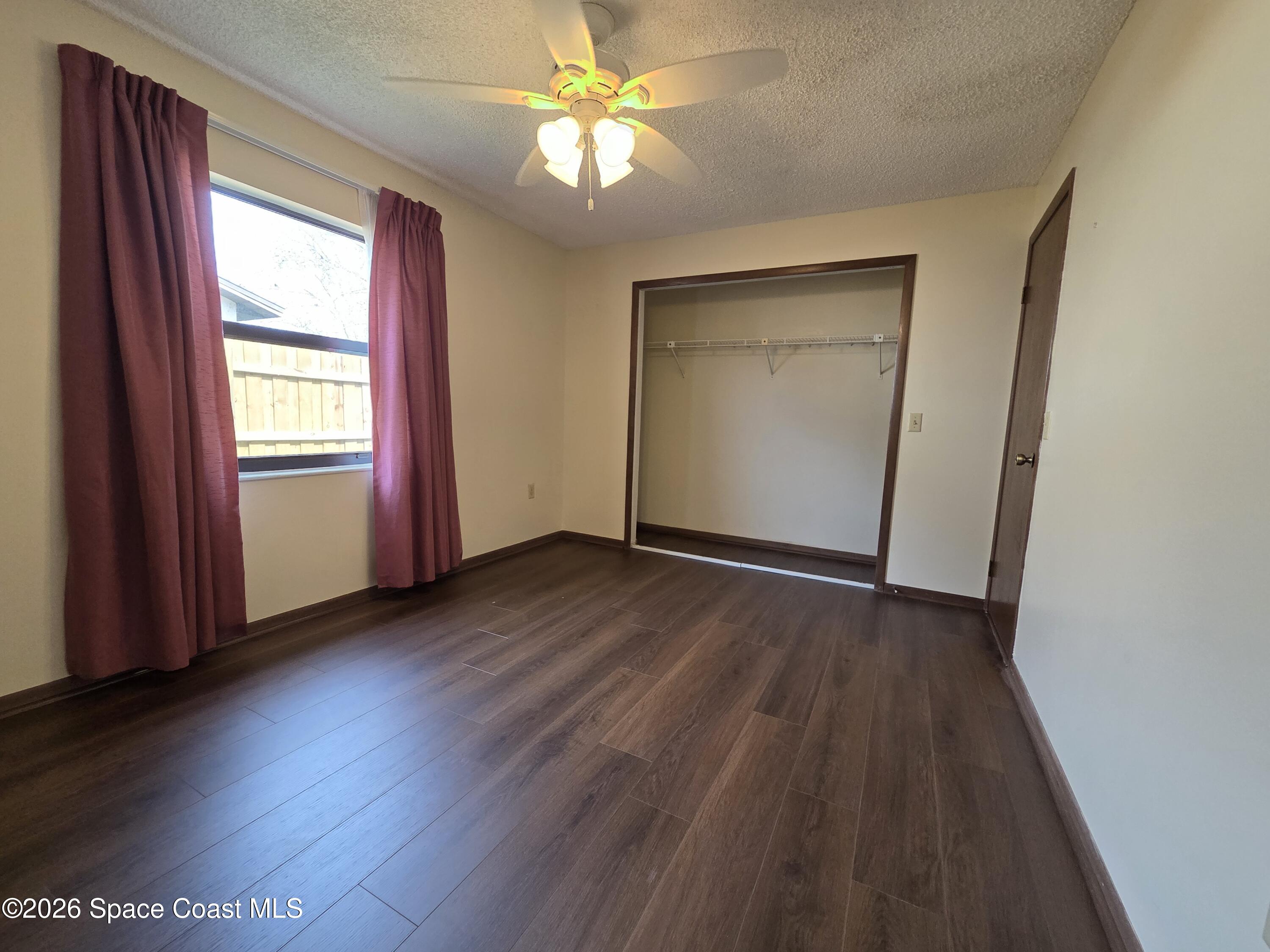 2591 Fulton Court Melbourne, FL 32935 - Photo 18 of 28 an empty room with wooden floor fan and windows