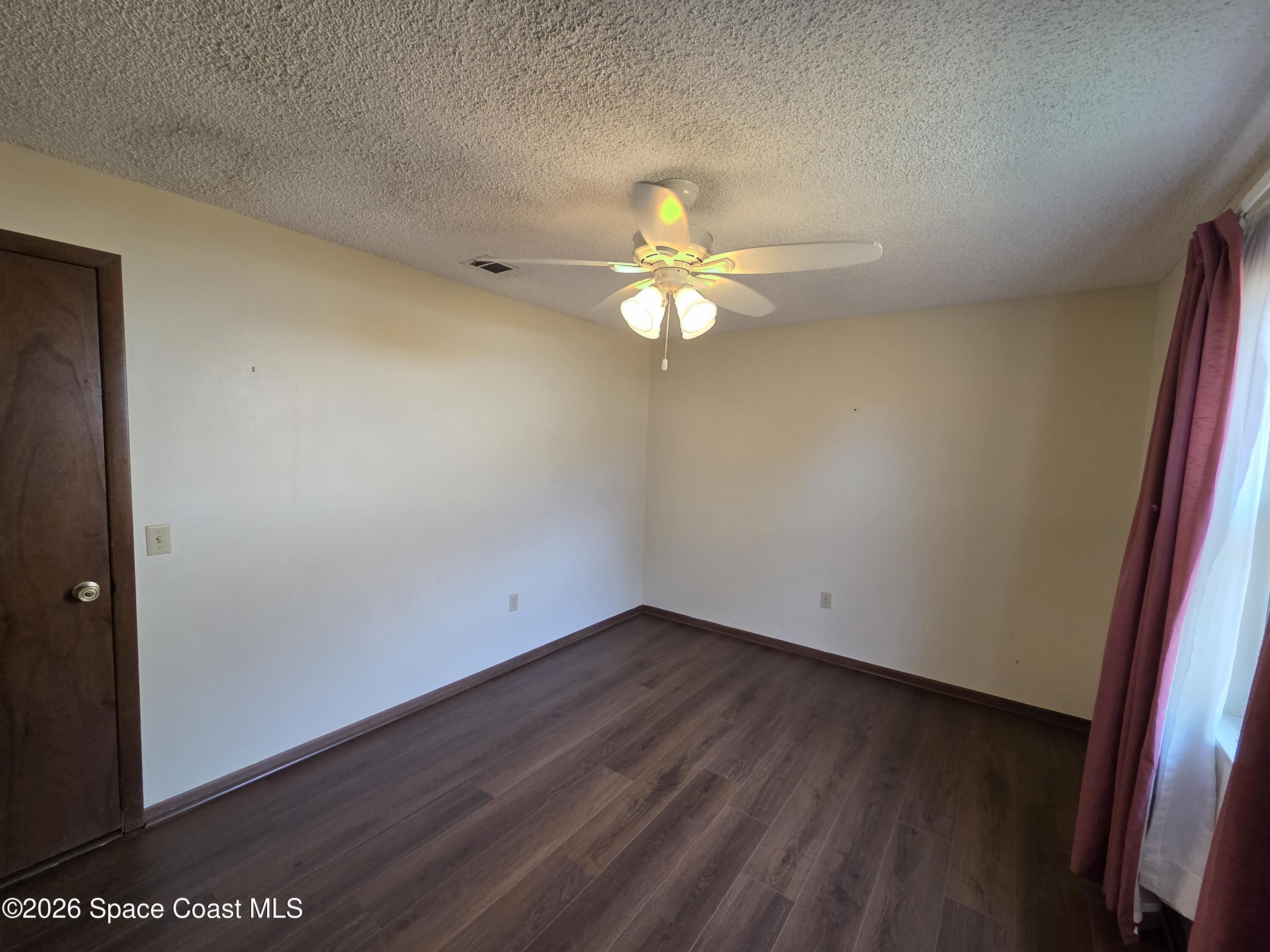 2591 Fulton Court Melbourne, FL 32935 - Photo 19 of 28 an empty room with a window and a chandelier fan