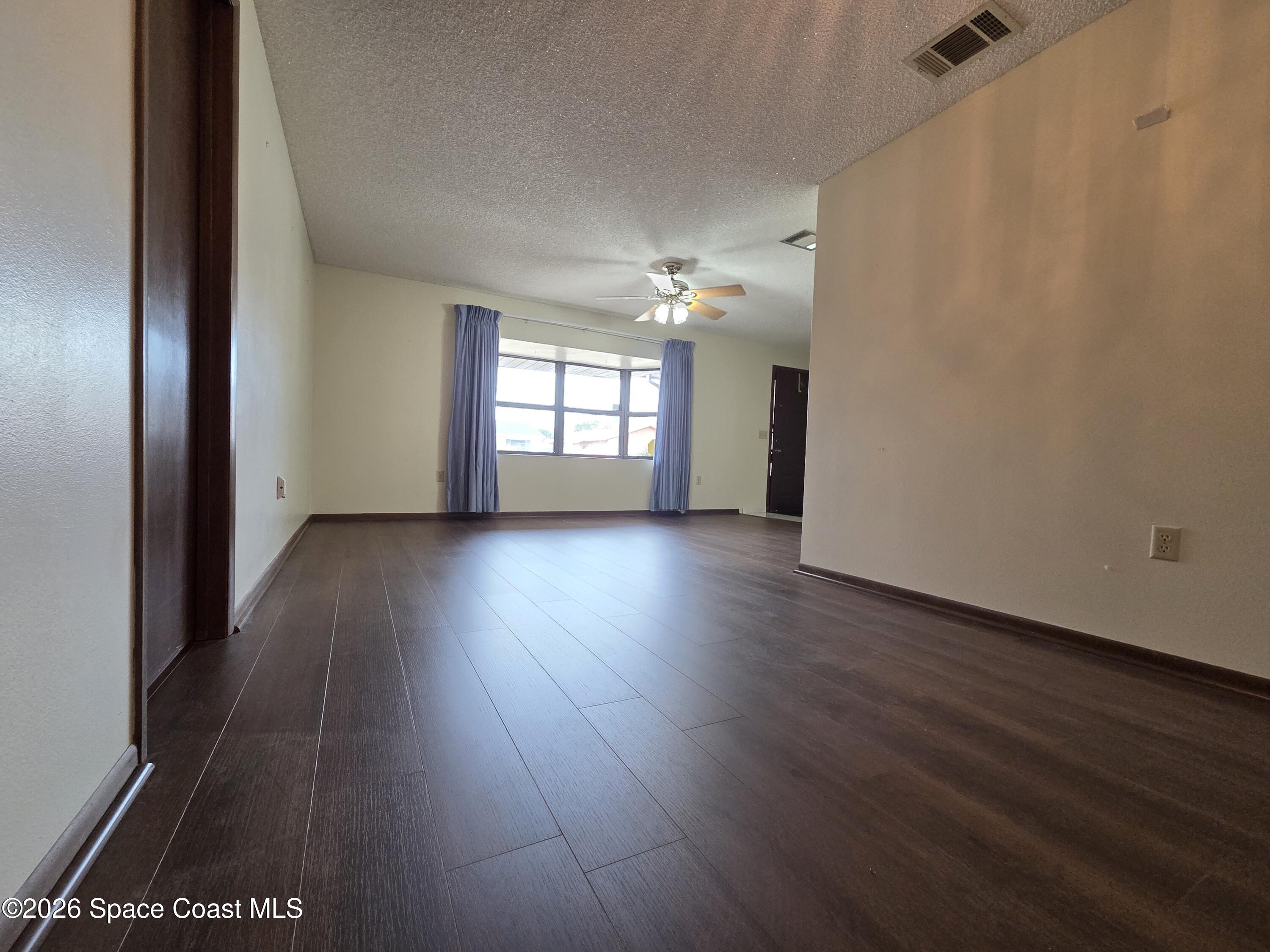 2591 Fulton Court Melbourne, FL 32935 - Photo 5 of 28 an empty room with wooden floor and windows