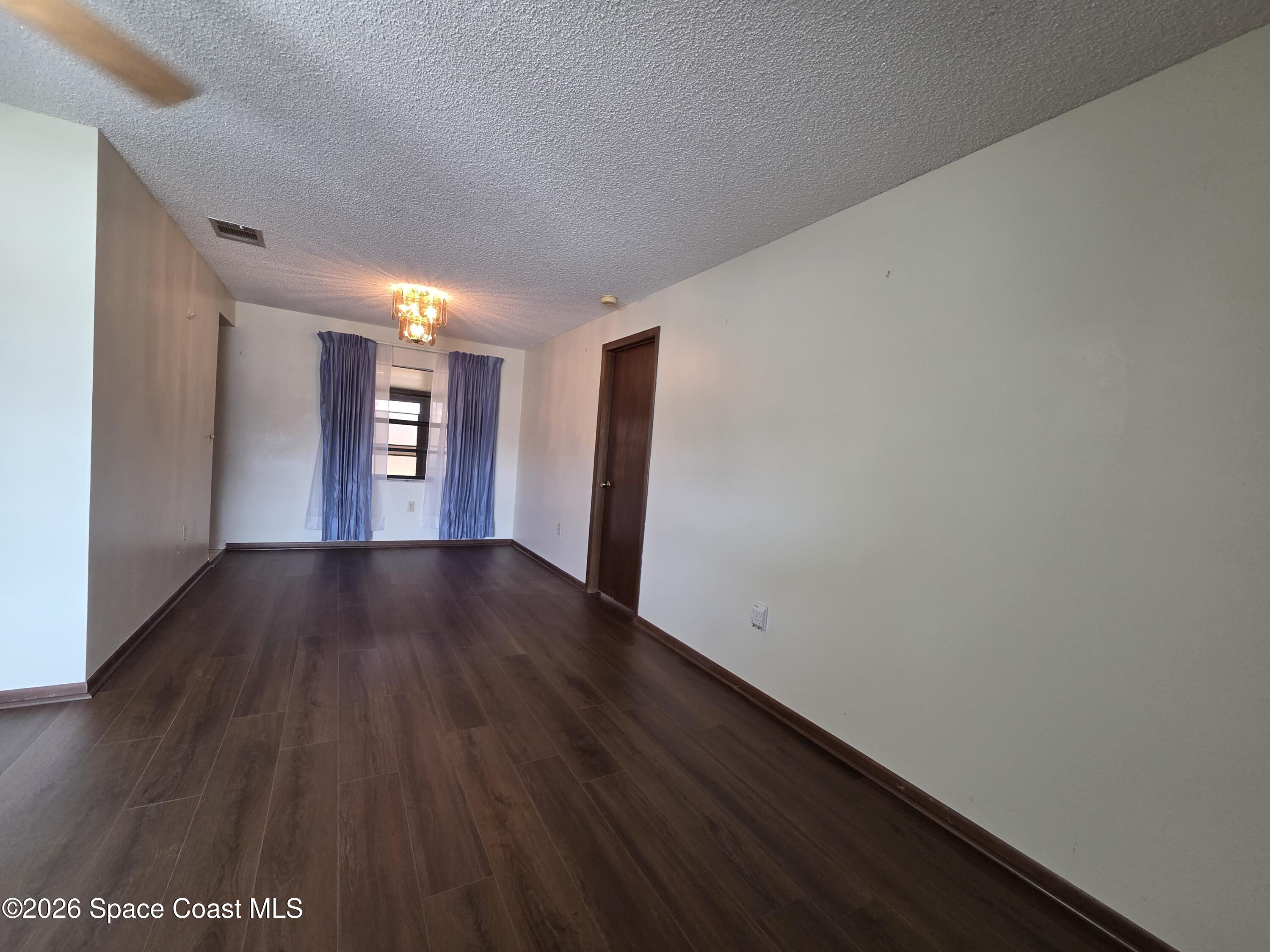 2591 Fulton Court Melbourne, FL 32935 - Photo 6 of 28 a view of empty room with window and wooden floor