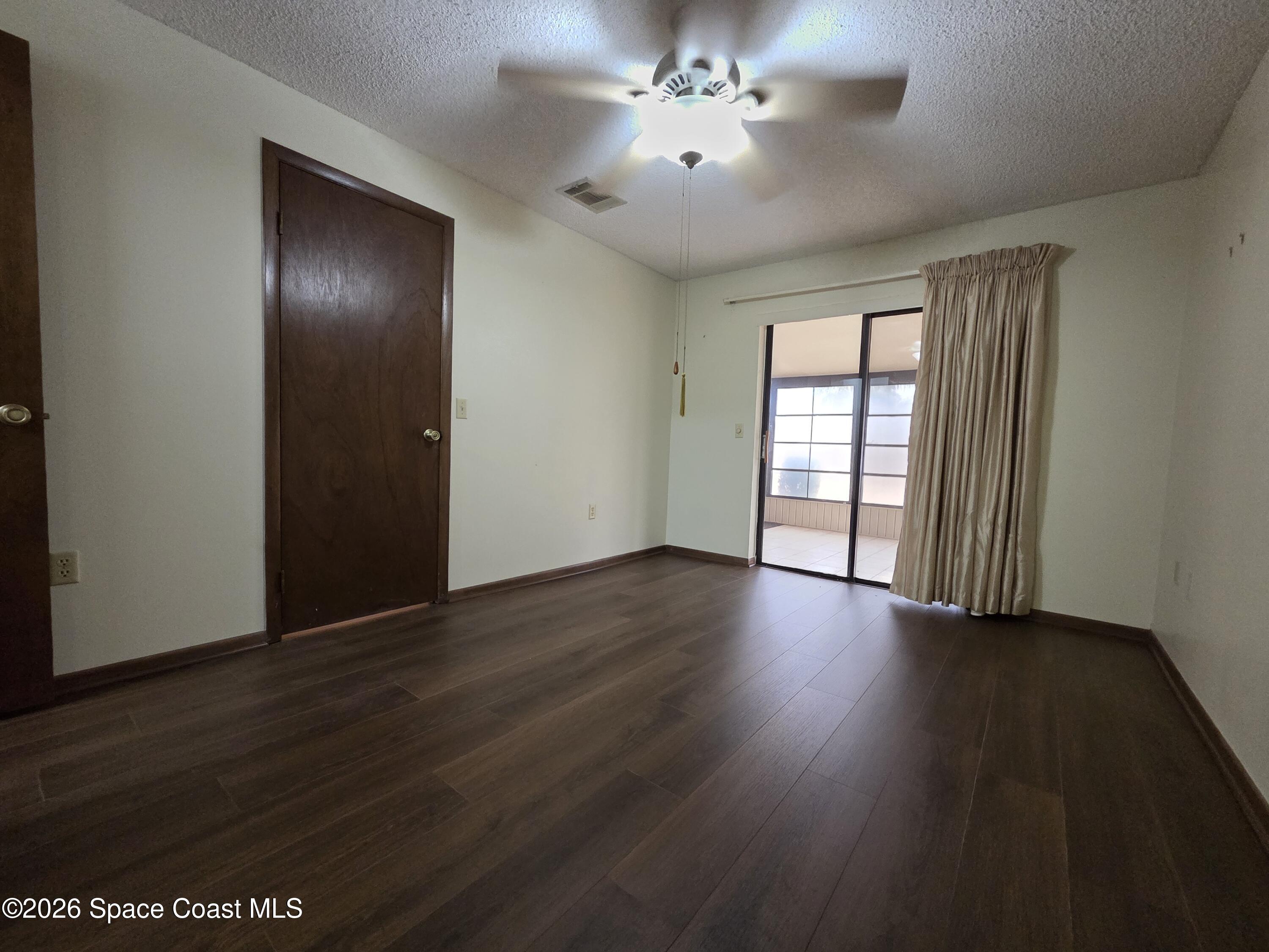 2591 Fulton Court Melbourne, FL 32935 - Photo 7 of 28 an empty room with wooden floor and windows