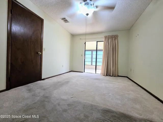 a view of an empty room with a ceiling fan