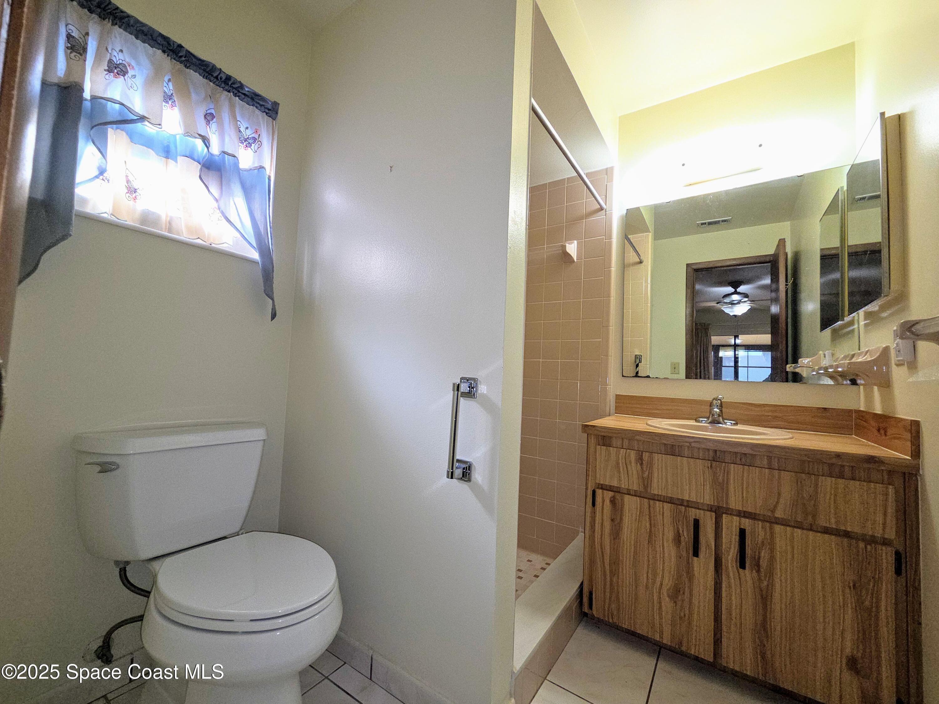 2591 Fulton Court Melbourne, FL 32935 - Photo 10 of 28 a bathroom with a granite countertop toilet sink and mirror