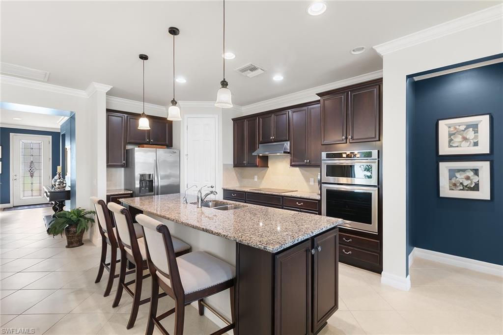8407 Benelli Court Naples, FL 34114 - Photo 14 of 50 a kitchen with stainless steel appliances granite countertop a kitchen island a stove and a sink