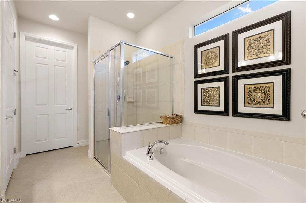 8407 Benelli Court Naples, FL 34114 - Photo 19 of 50 a bathroom with a bathtub and a shower