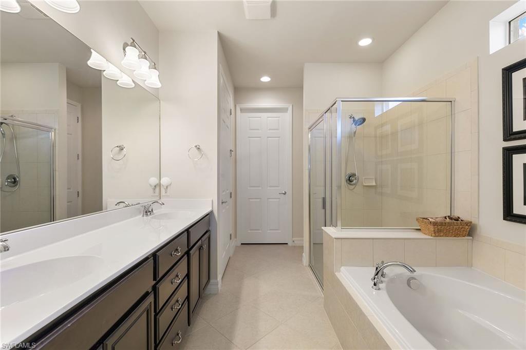 8407 Benelli Court Naples, FL 34114 - Photo 20 of 50 a spacious bathroom with a tub sink shower and mirror