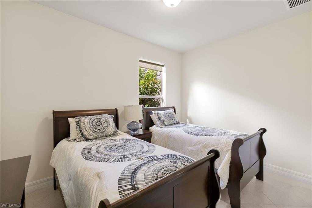 8407 Benelli Court Naples, FL 34114 - Photo 23 of 50 a bedroom with two beds and a table