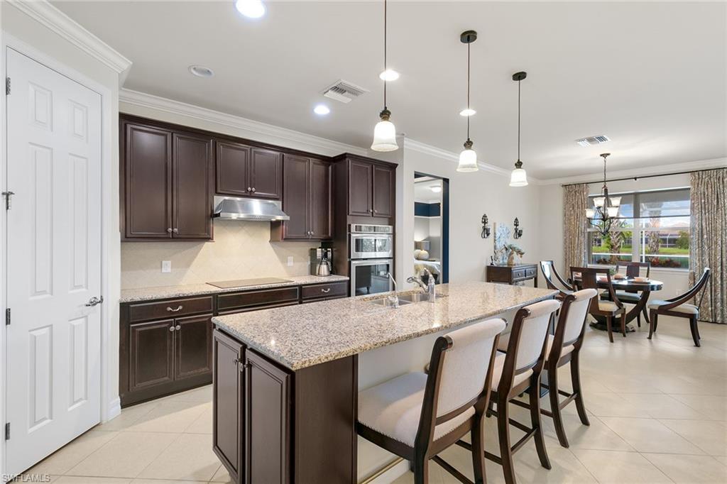 8407 Benelli Court Naples, FL 34114 - Photo 3 of 50 a kitchen with a table and chairs in it