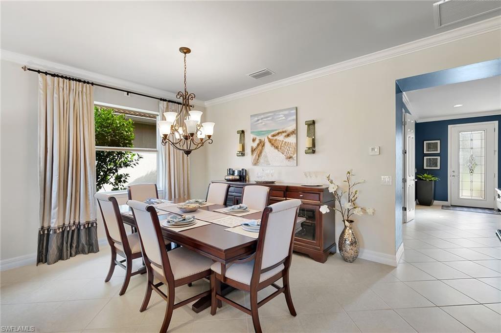 8407 Benelli Court Naples, FL 34114 - Photo 10 of 50 a dining room with furniture a chandelier and a rug