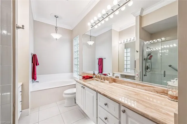 a spacious bathroom with a granite countertop sink a toilet and a shower