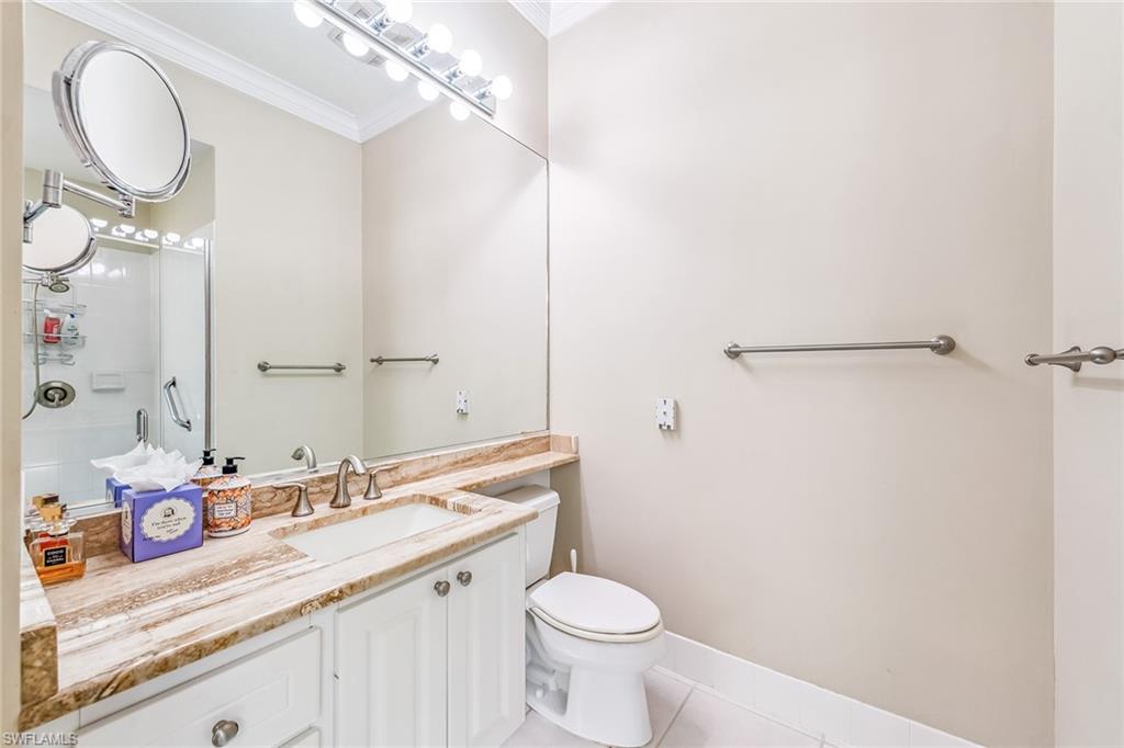 2881 Hatteras Way Naples, FL 34119 - Photo 16 of 32 a bathroom with a granite countertop sink mirror vanity and toilet
