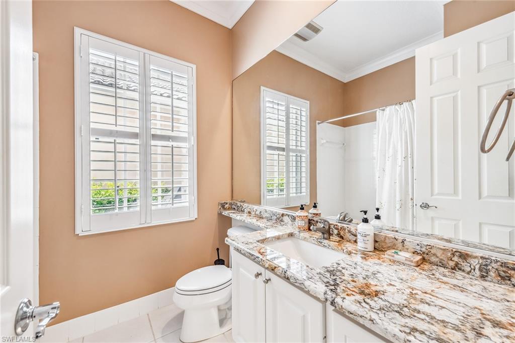 2881 Hatteras Way Naples, FL 34119 - Photo 22 of 32 a bathroom with a granite countertop sink toilet and large mirror