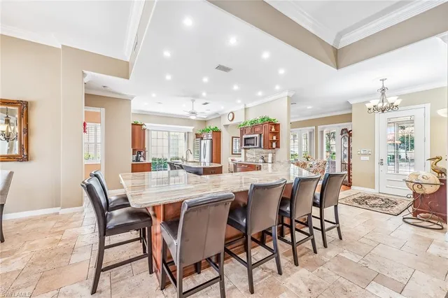 a dining room with stainless steel appliances kitchen island granite countertop a table and chairs