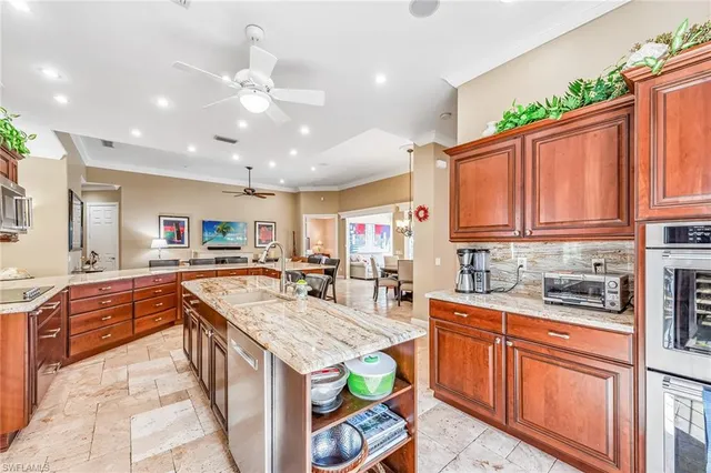 a kitchen with kitchen island granite countertop a sink stove and cabinets