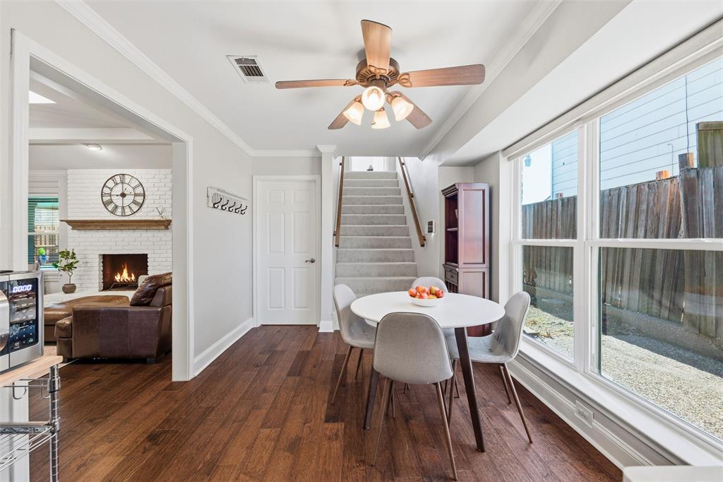 1704 Throwbridge Lane Plano, TX 75023 - Photo 16 of 40 Breakfast area features smooth ceiling with crown molding and a ceiling-mounted fan with light kit. Large window provides natural light, with hardwood flooring extending throughout and direct access to adjacent kitchen and stairway areas.