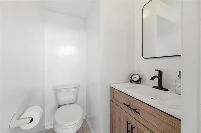 a bathroom with a toilet sink vanity and mirror
