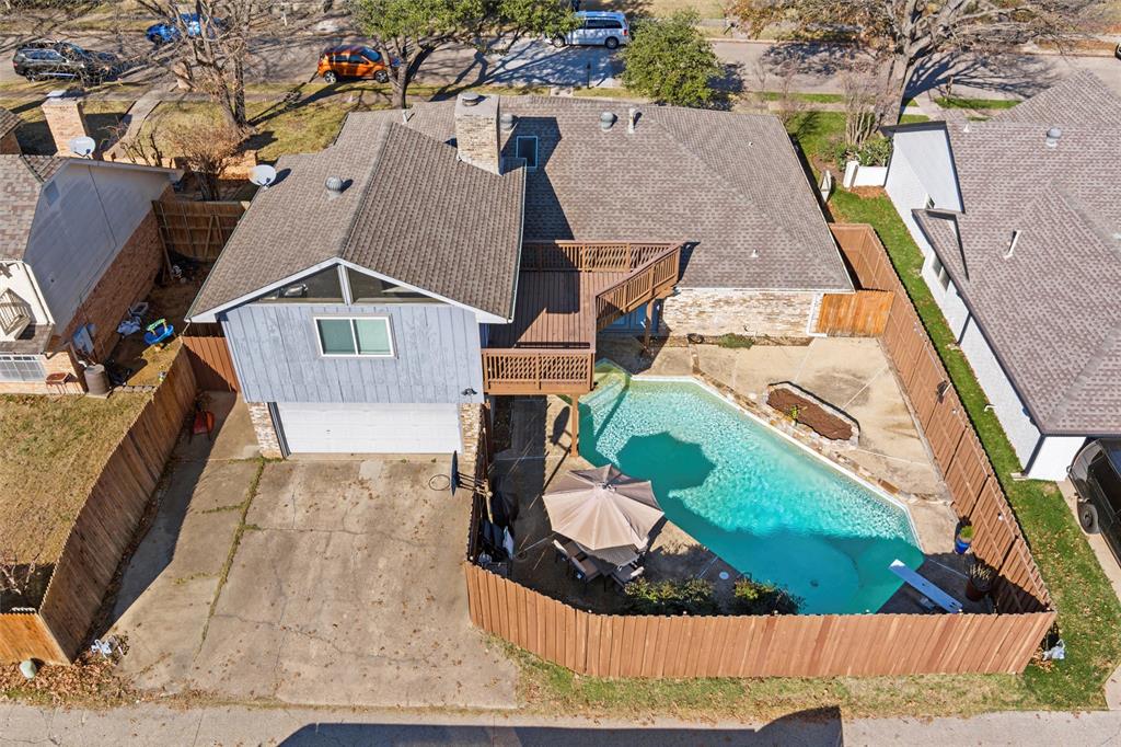1704 Throwbridge Lane Plano, TX 75023 - Photo 38 of 40 Aerial views show the fenced backyard with a saltwater swimming pool and concrete decking. A raised wood deck is connected to the upstairs room and overlooks the pool area.