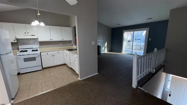 a kitchen with granite countertop white cabinets and stainless steel appliances