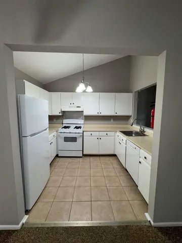 a kitchen with cabinets oven and a sink