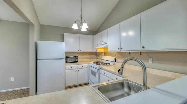 a kitchen with a refrigerator a sink and cabinets