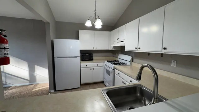 a kitchen with stainless steel appliances granite countertop a sink a stove a refrigerator and cabinets