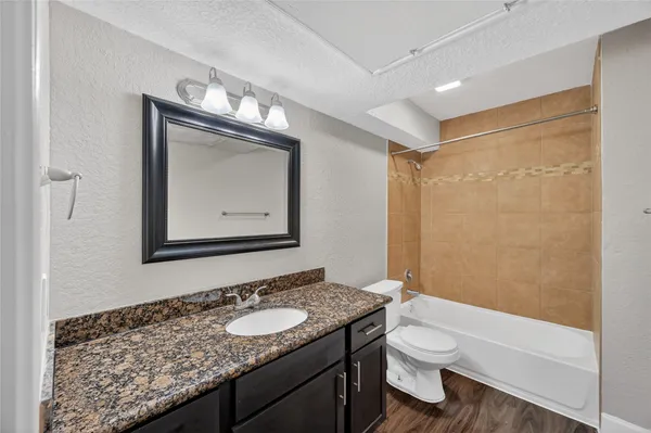 a bathroom with a granite countertop sink toilet and shower