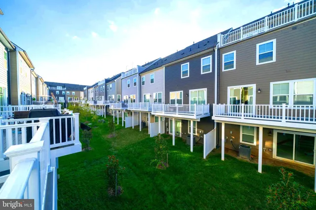 a view of an apartment with a deck and a big yard