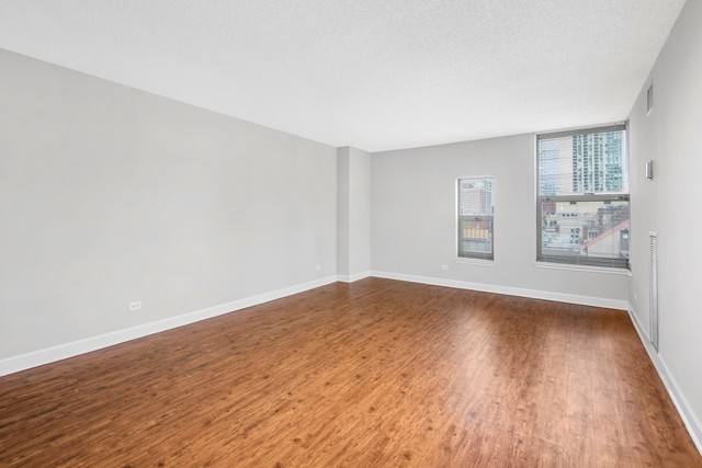 100 West Chestnut Street, Unit 1505 Chicago, IL 60610 - Photo 14 of 16 a view of empty room with wooden floor and fan