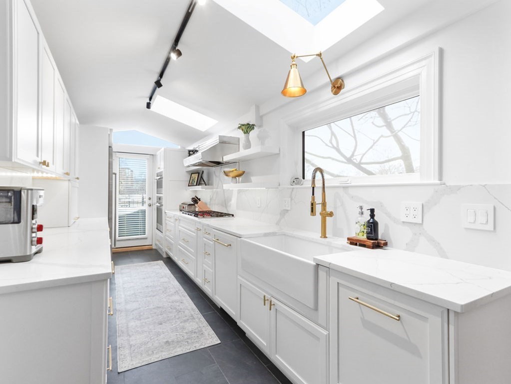 206 Beacon Street, Unit 1 Boston, MA 02116 - Photo 7 of 23 a large white kitchen with cabinets a sink and appliances
