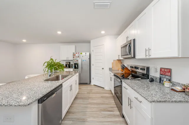 a kitchen with granite countertop lots of counter space and stainless steel appliances