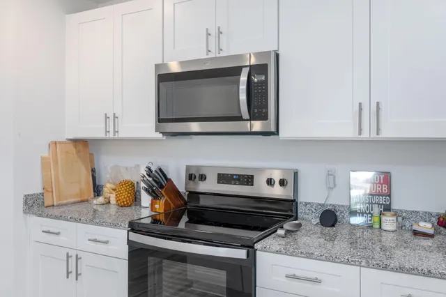 a kitchen with granite countertop a stove and a microwave