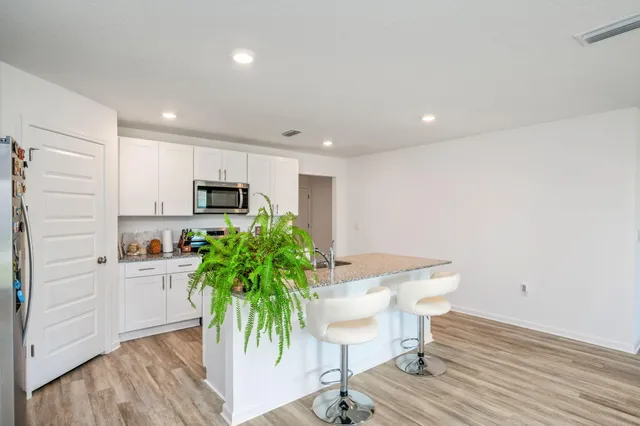 a kitchen with granite countertop white cabinets and stainless steel appliances