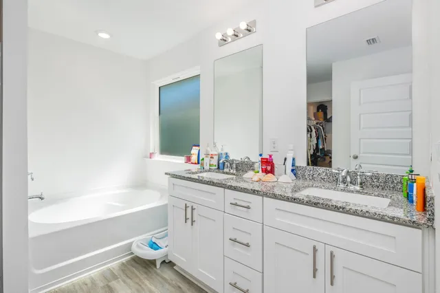 a bathroom with a bathtub sink and mirror