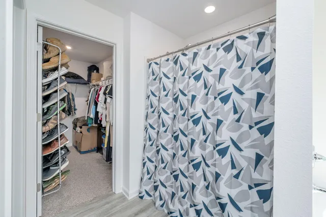 a view of walk in closet with clothes and shoes