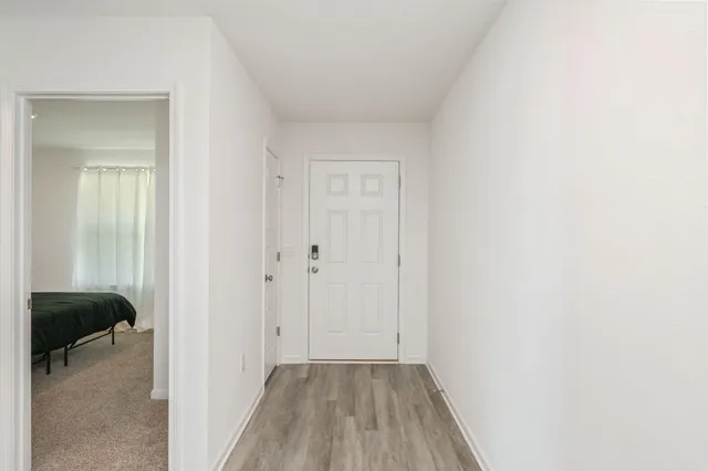 a view of hallway with a closet and wooden floor