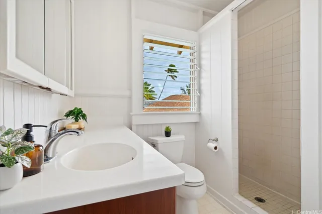 a bathroom with a sink a toilet and shower