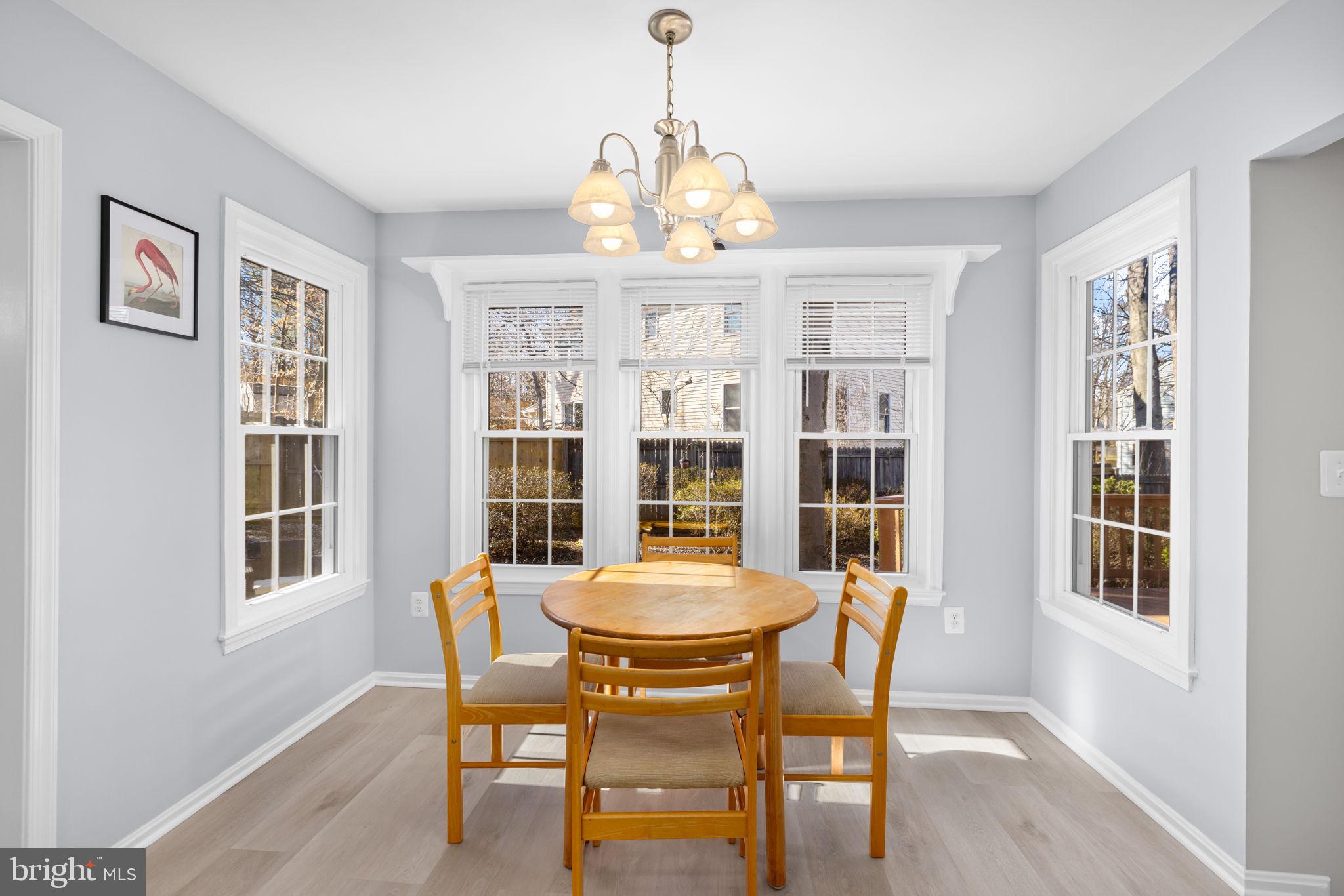 9451 Lapstrake Lane Burke, VA 22015 - Photo 11 of 59 a dining room with furniture a chandelier and wooden floor