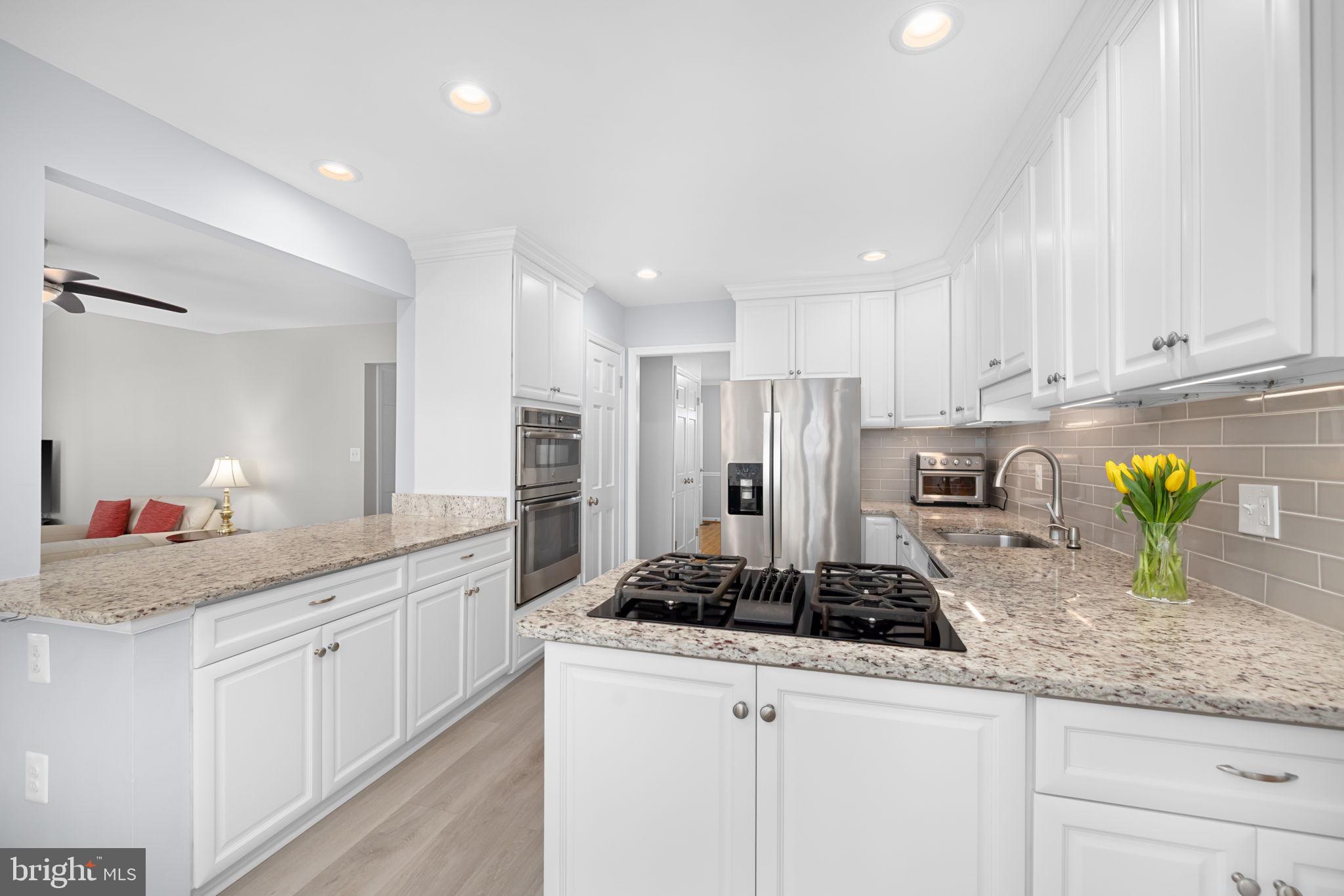 9451 Lapstrake Lane Burke, VA 22015 - Photo 13 of 59 a kitchen with sink a stove and cabinets