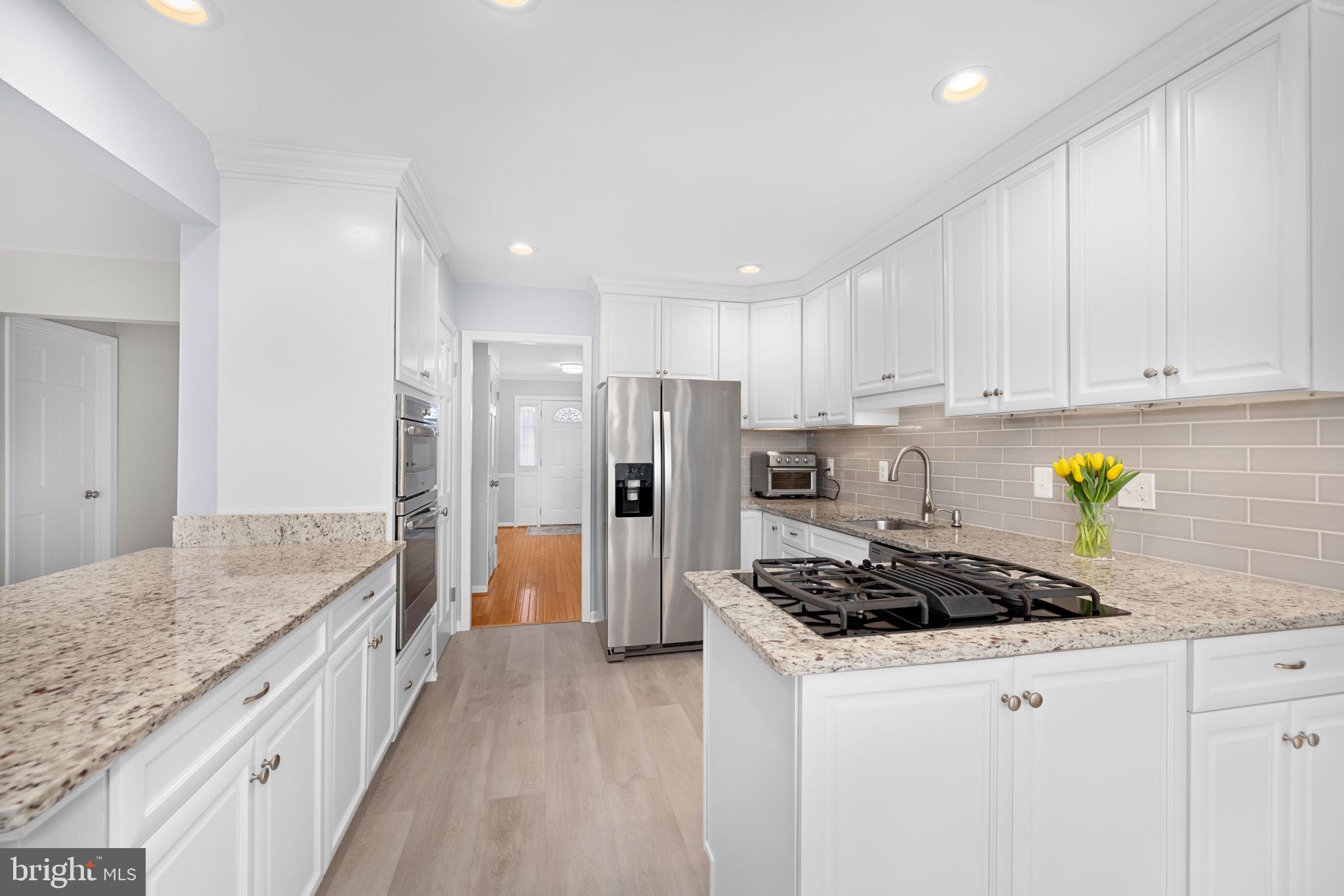 9451 Lapstrake Lane Burke, VA 22015 - Photo 14 of 59 a kitchen with stainless steel appliances granite countertop a stove a refrigerator a sink a counter space and cabinets