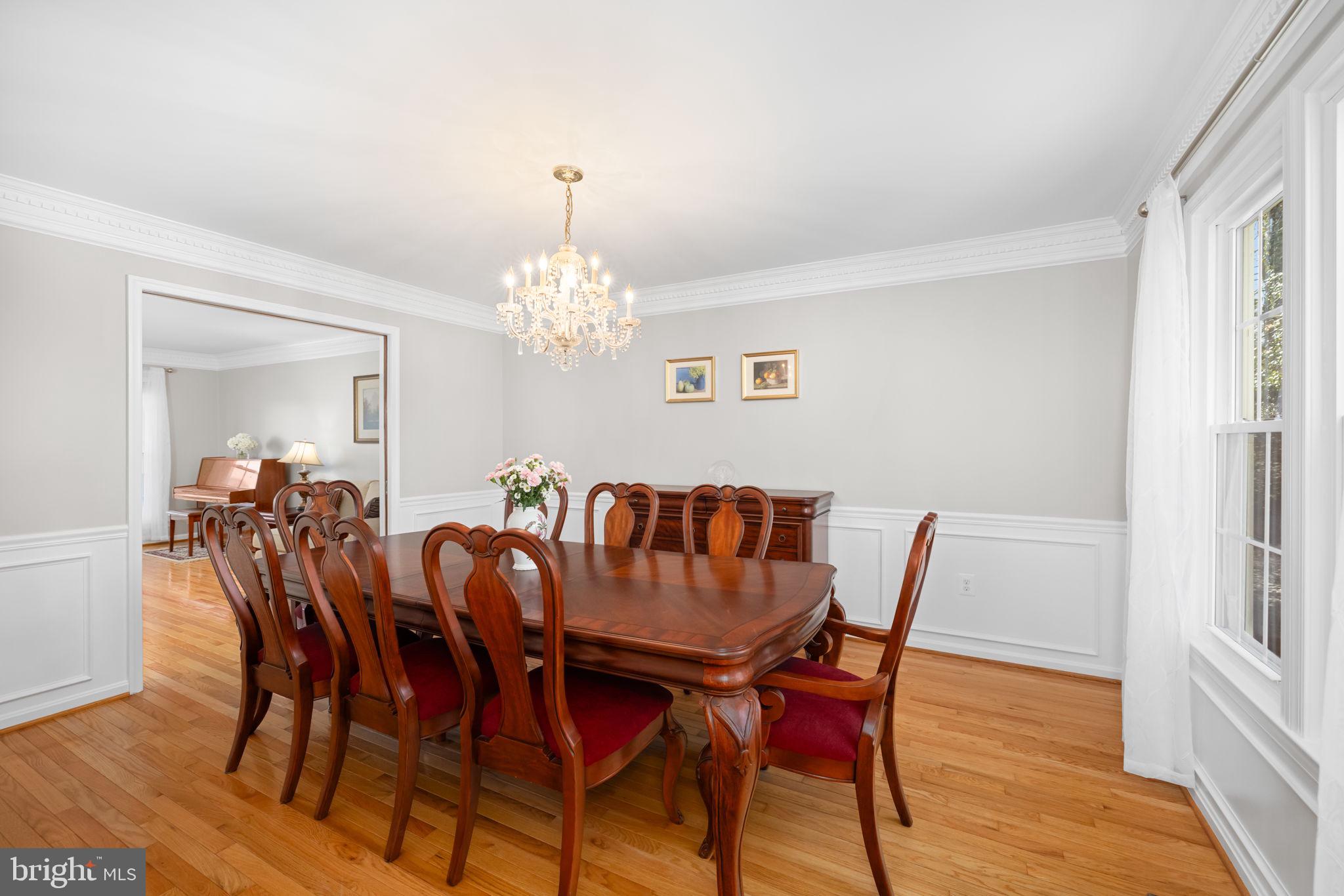 9451 Lapstrake Lane Burke, VA 22015 - Photo 22 of 59 a view of a dining room with furniture a chandelier and wooden floor