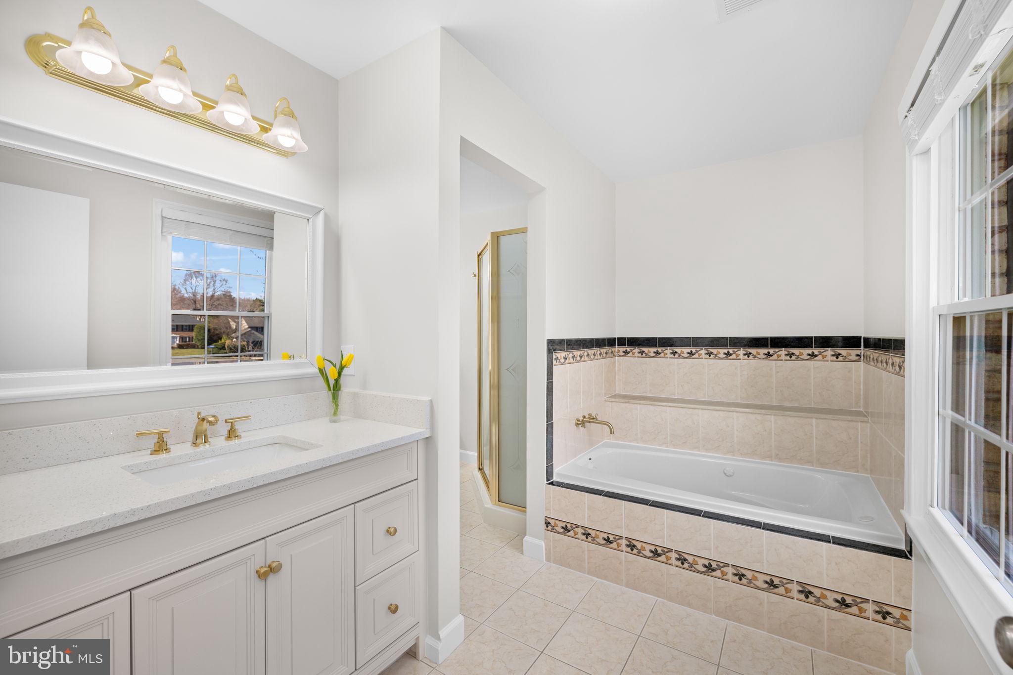 9451 Lapstrake Lane Burke, VA 22015 - Photo 30 of 59 a bathroom with a granite countertop sink a mirror and a bathtub