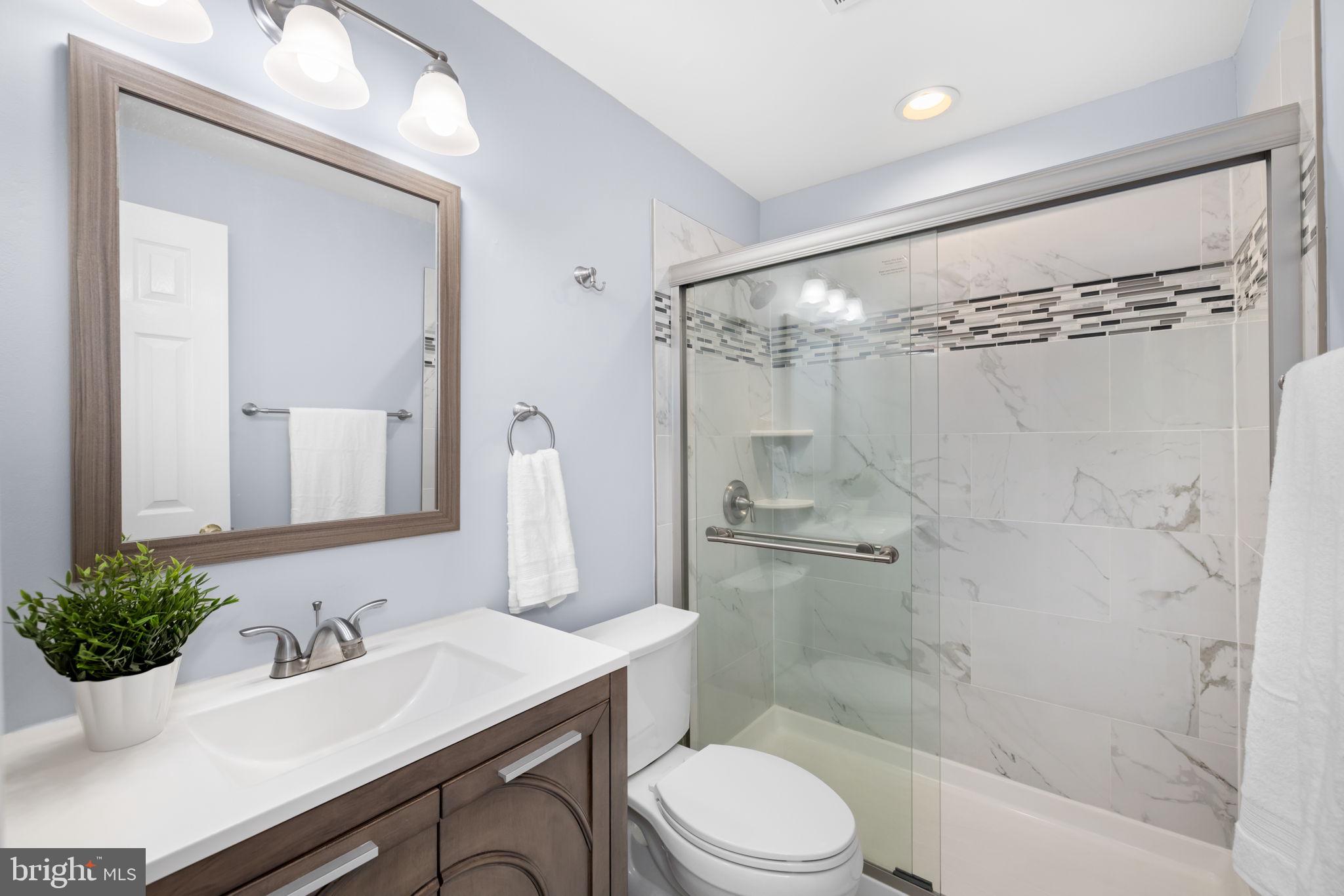 9451 Lapstrake Lane Burke, VA 22015 - Photo 42 of 59 a bathroom with a sink toilet a mirror and shower