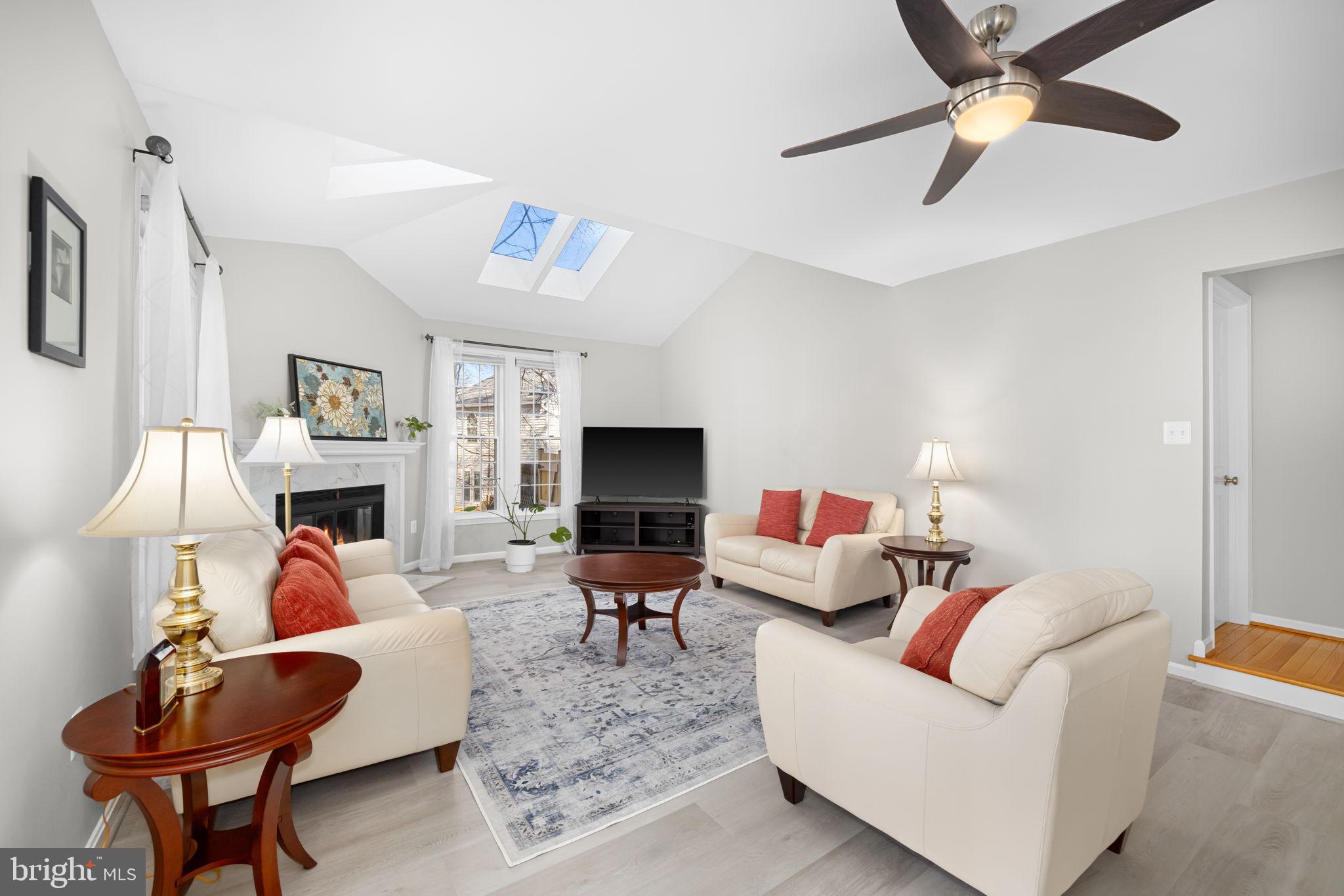 9451 Lapstrake Lane Burke, VA 22015 - Photo 8 of 59 a living room with furniture a fireplace and a flat screen tv