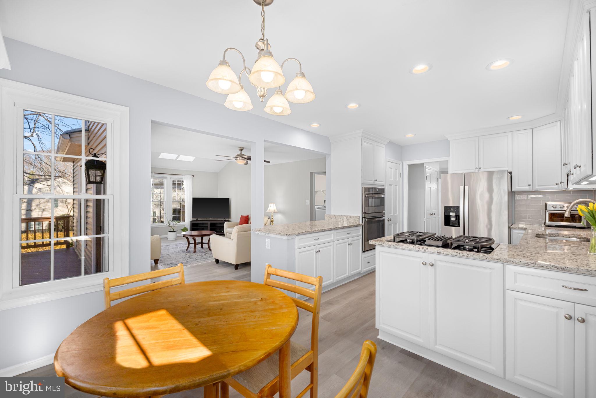9451 Lapstrake Lane Burke, VA 22015 - Photo 10 of 59 a kitchen with stainless steel appliances kitchen island granite countertop a sink and cabinets