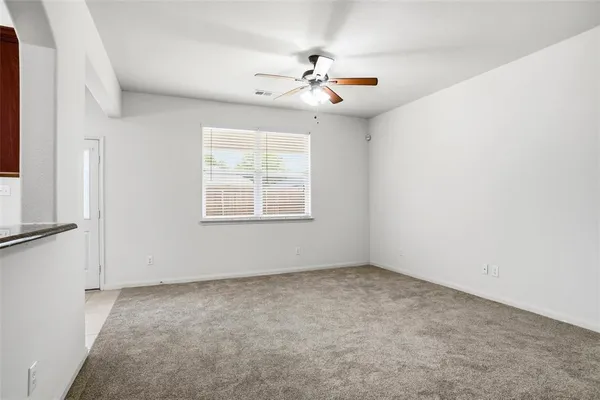 an empty room with a window and a ceiling fan