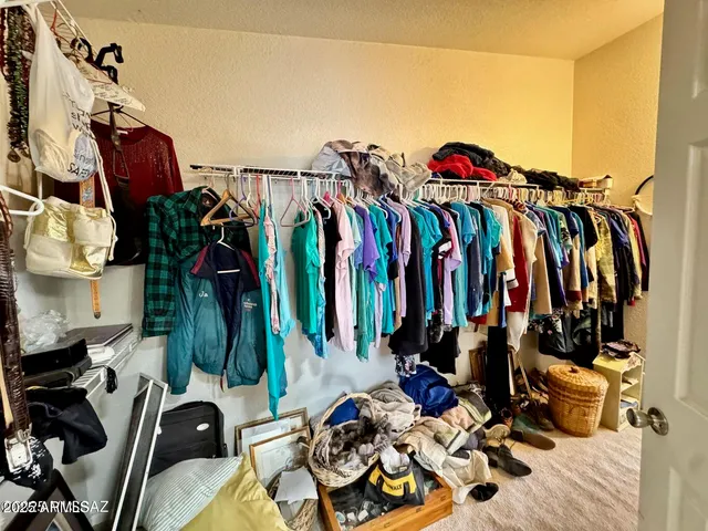 a view of walk in closet with clothes