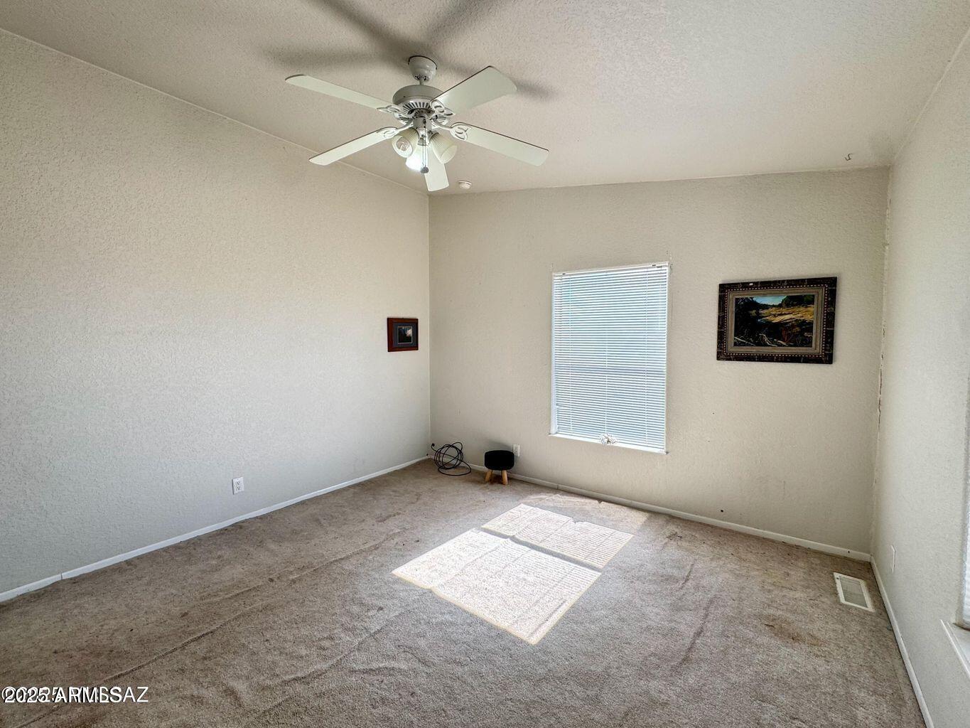 2627 West Hansen Road Willcox, AZ 85643 - Photo 18 of 42 an empty room with windows and fan
