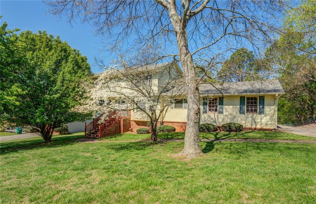 a view of a house with yard and tree s